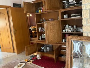 Kast met servies die wordt leeggemaakt en ingepakt