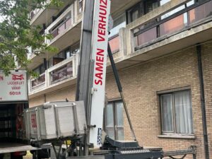 Ladderlift van Samen Verhuizen aan een hoog appartementsgebouw
