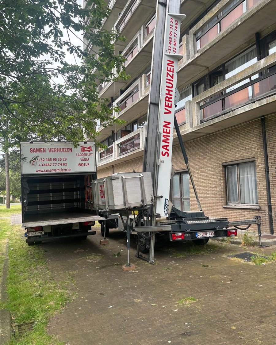 Ladderlift van Samen Verhuizen opgesteld aan een hoog appartementsgebouw